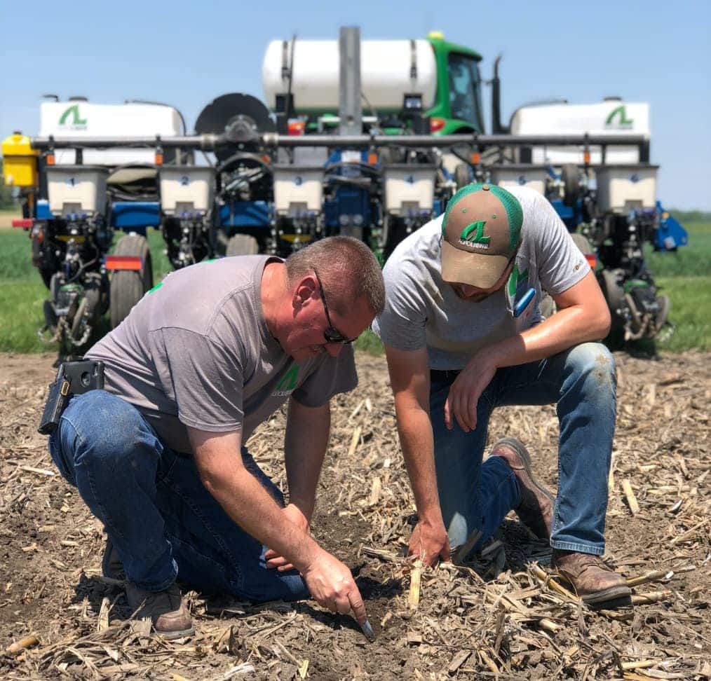 Agroliquid employees inspecting soil